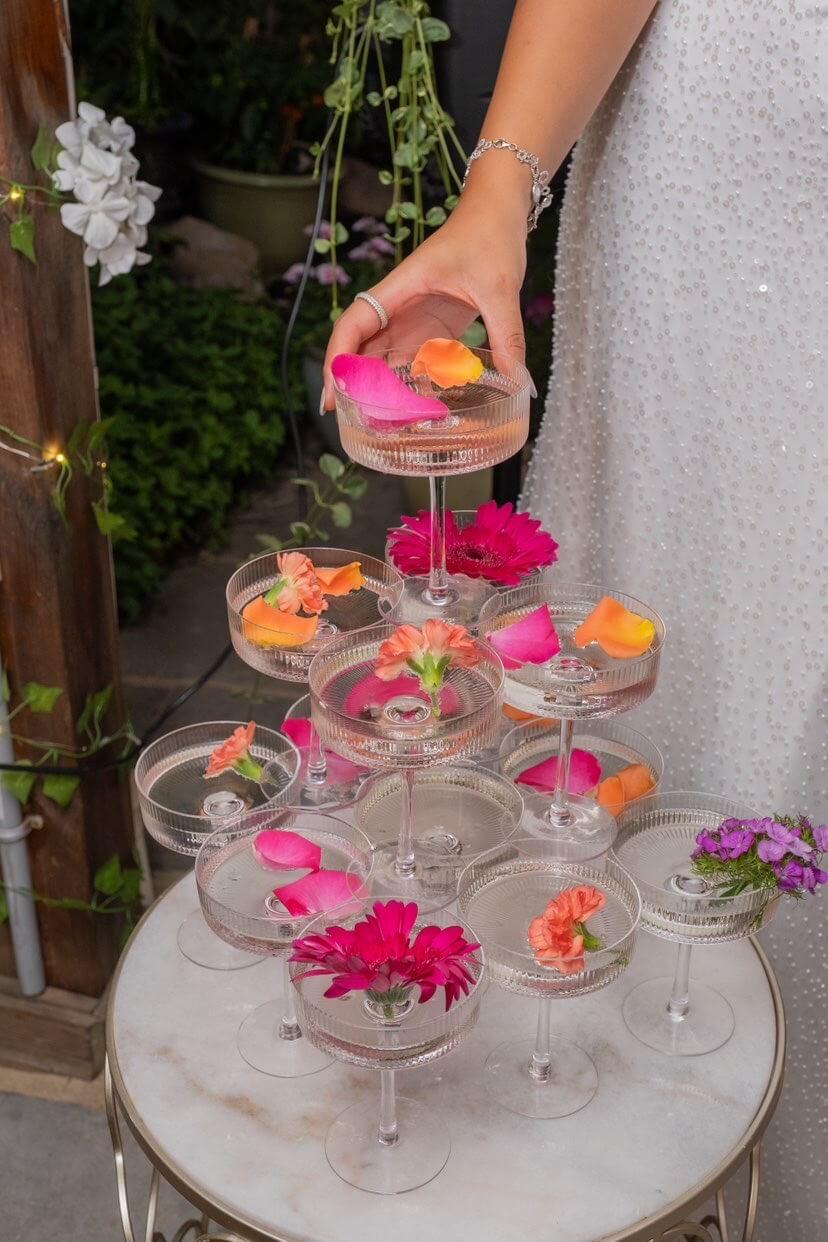Tiered coupe mocktails with peach-pink floral garnishes