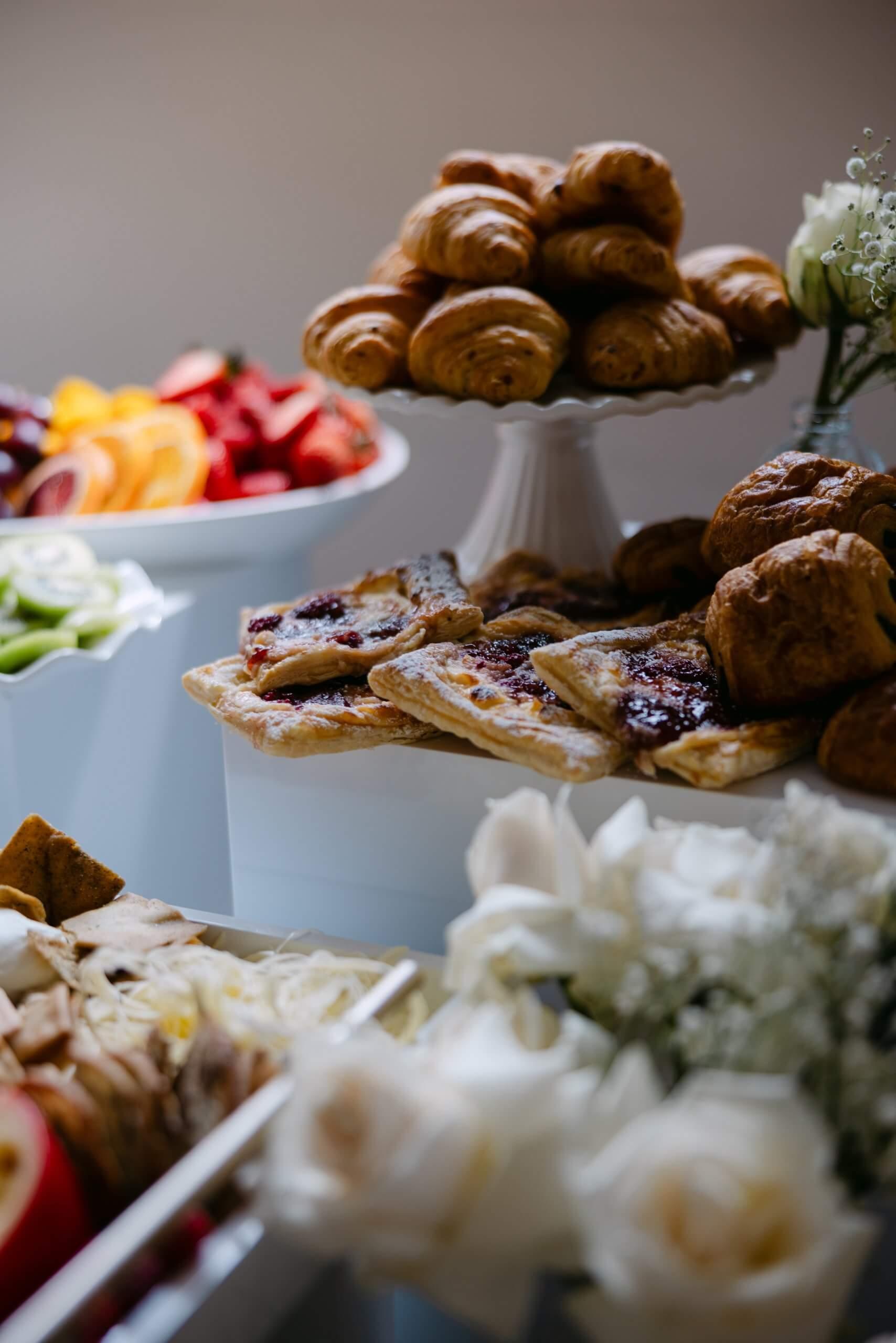 Pastry brunch table with croissants, fruit, and soft florals